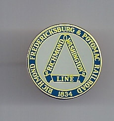 Color photo of metal pin with RF&P railroad logo from 1949. Blue and gold over gray background.
