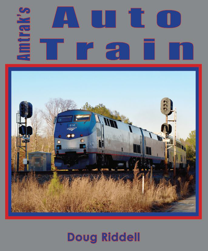 Color photograph of the cover of the book Amtrak's Auto Train by Doug Riddell. Cover is silver with a color photo of an Amtrak Auto Train powered by two diesel locomotives passing by signals. Photo of train is outlined in blue and red. Text on cover in blue outlined in red.